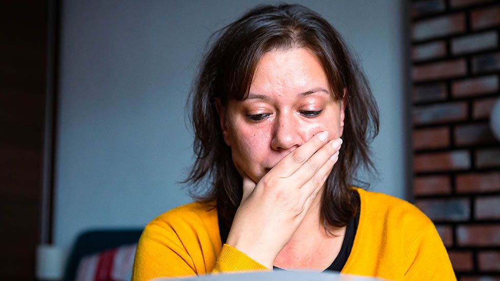 Anxious woman looks at bills