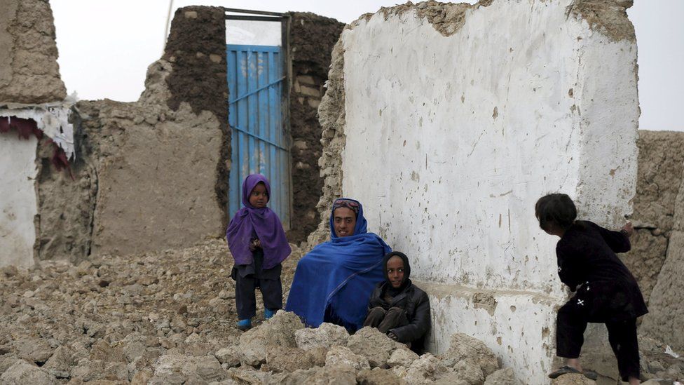 Internally displaced Afghans sit outside their shelter in Kabul, Afghanistan March 9, 2016
