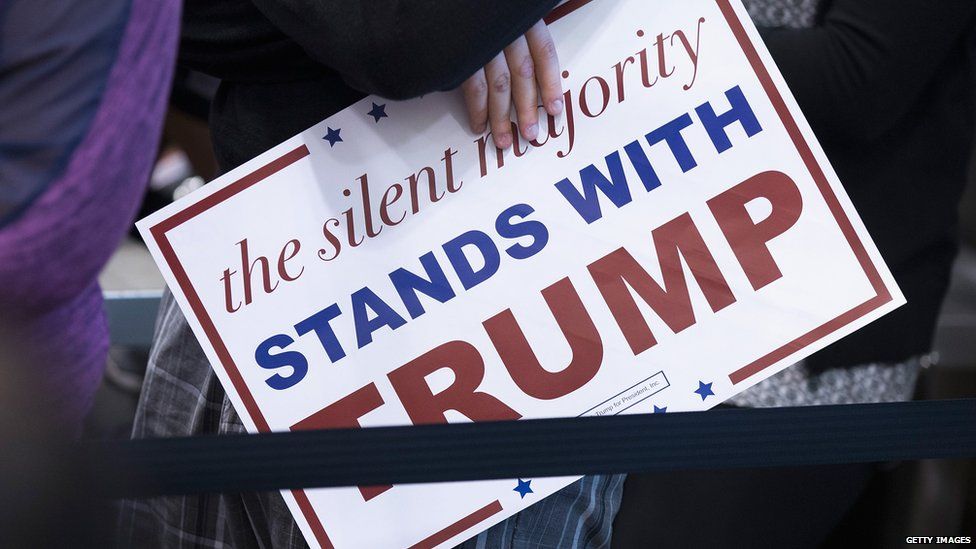 A sign reads: "The silent majority stands with Trump"
