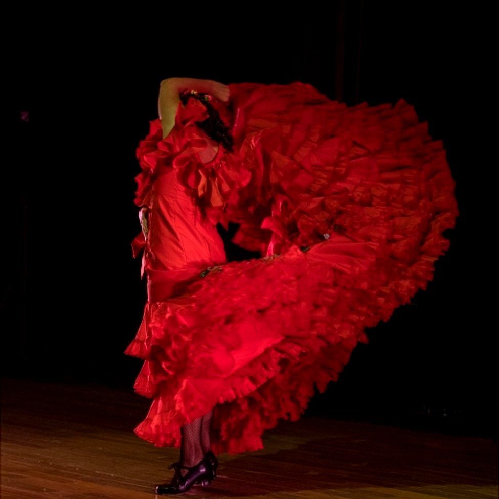 Spanish flamenco dancer Maria Moreno spins in a red, ruffled flamenco dress.