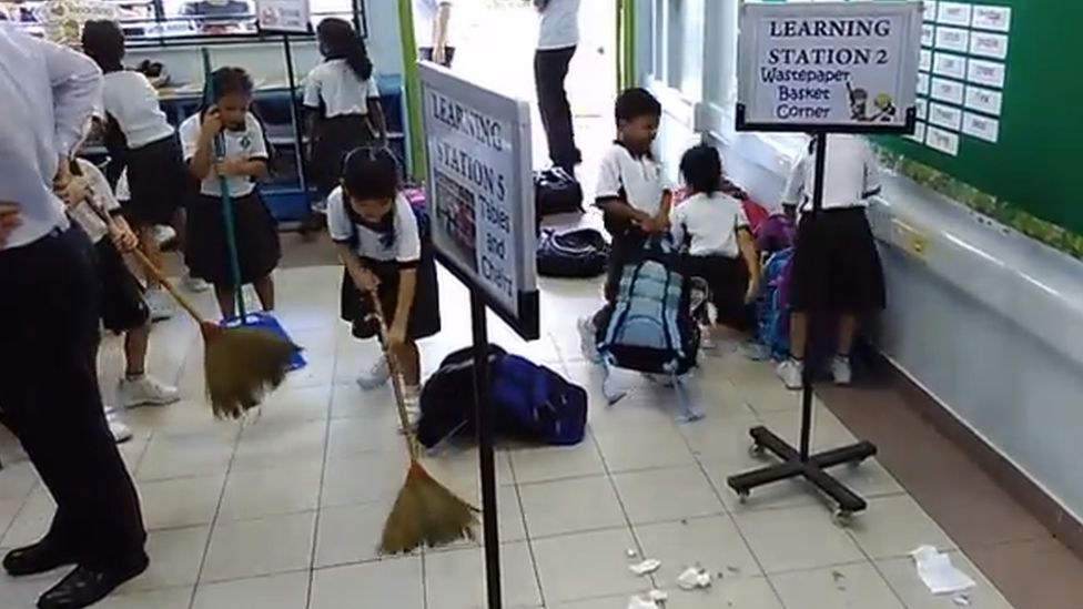 Singapore primary school pupils sweeping in a classroom