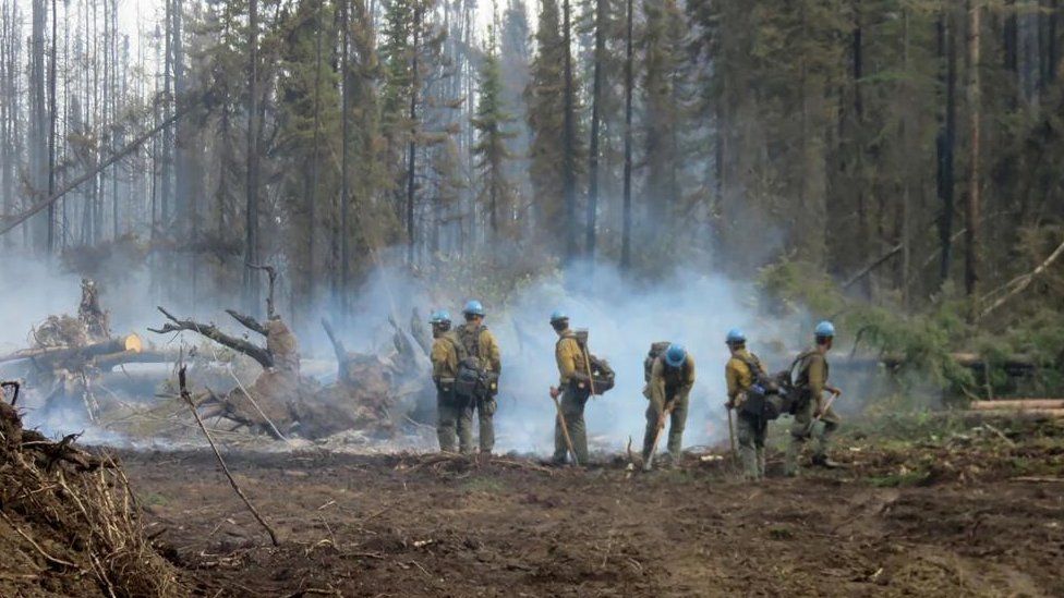 American firefighters work on the Basset Complex wildfire near Paddle Prairie Metis Settlement, Alberta, Canada July 10, 2023.