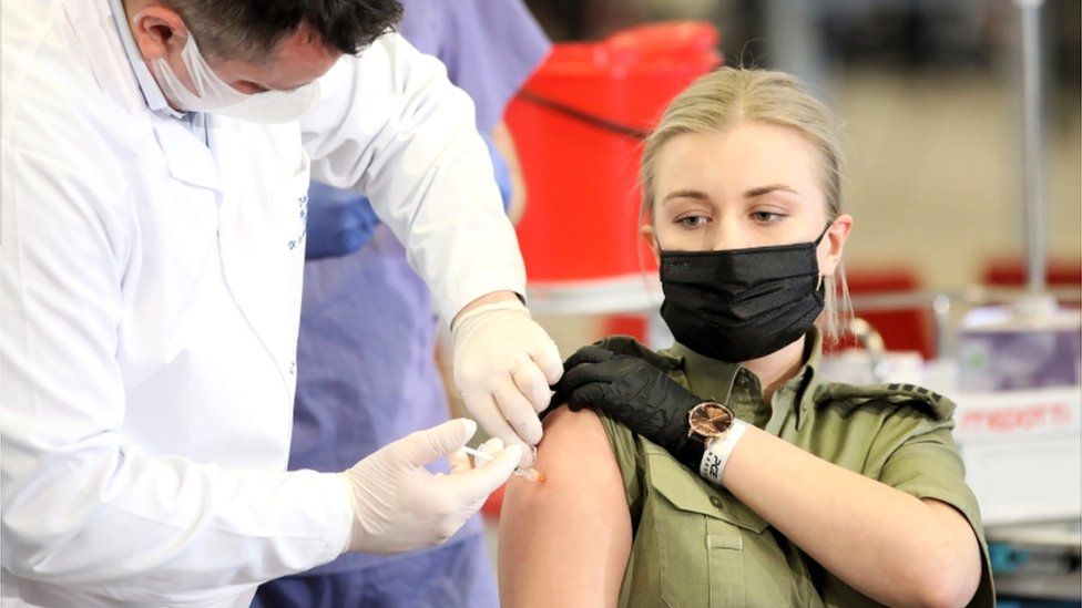 Members of uniformed services receive the AstraZeneca Covid-19 vaccine at the National Stadium in Warsaw