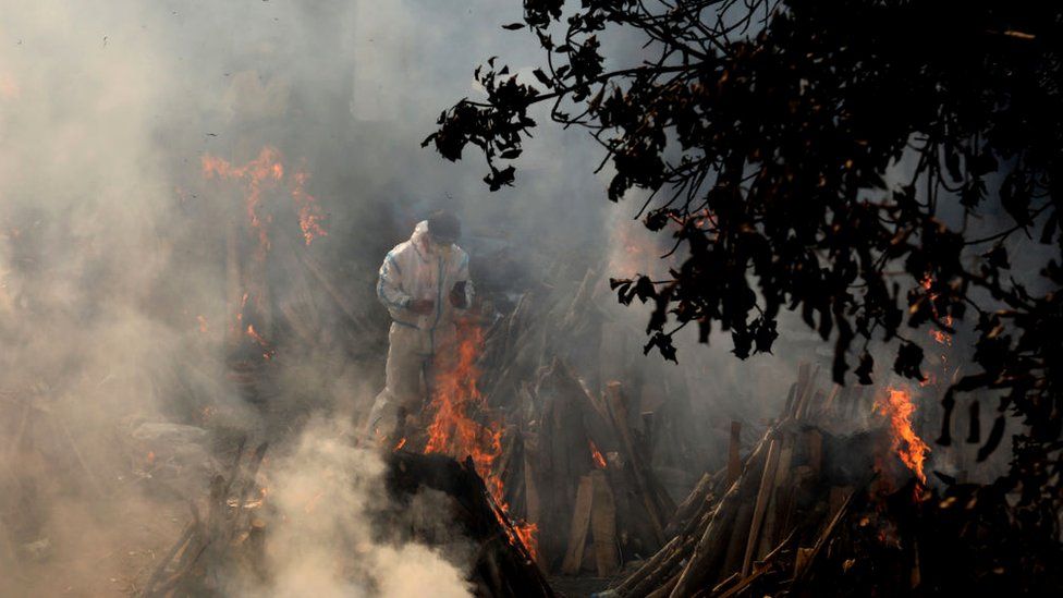 Image shows a relative at the site of makeshift funeral pyres