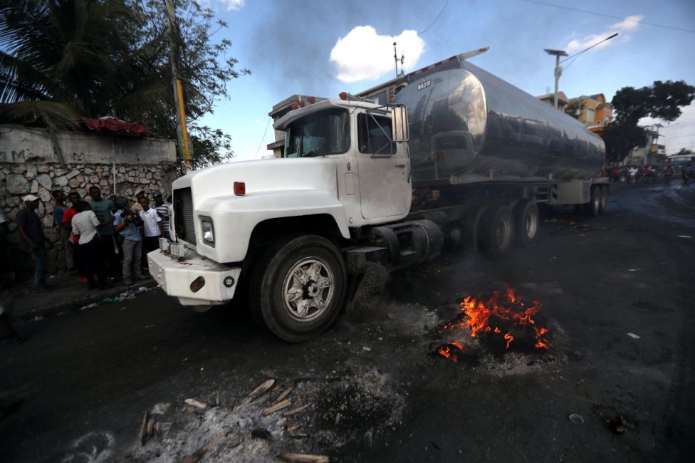 A truck with a fuel container travels along a blocked road during anti-government protests in Port-au-Prince