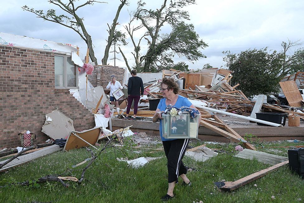 Volunteers clean up after a tornado touched down in Nevada, Iowa