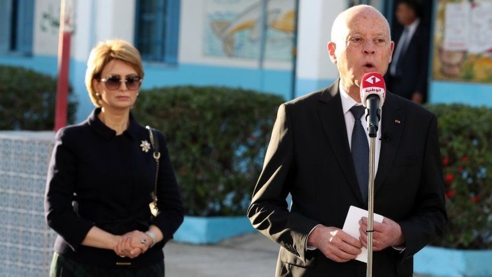 Президент Туниса Кайс Сайед (справа) стоит рядом со своей женой, когда он разговаривает с журналистами после голосования в Тунисе. Фото: 17 декабря 2022 г.