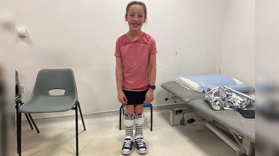 Imogen standing with splints