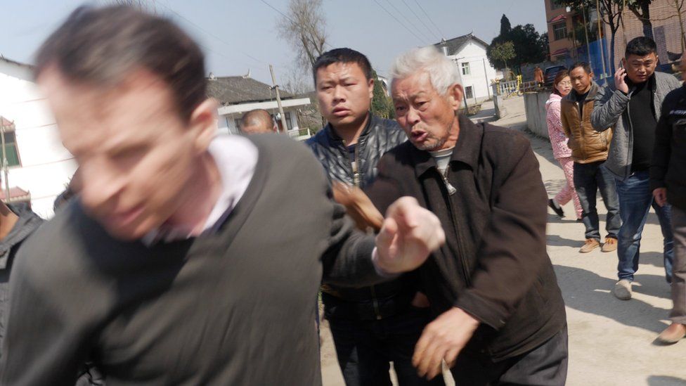 Picture of BBC journalist John Sudworth being forced away from a Chinese village