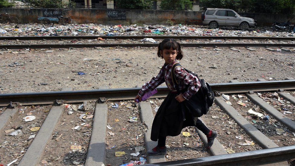 An Indian girl walks along train tracks in New Delhi on October 13, 2015