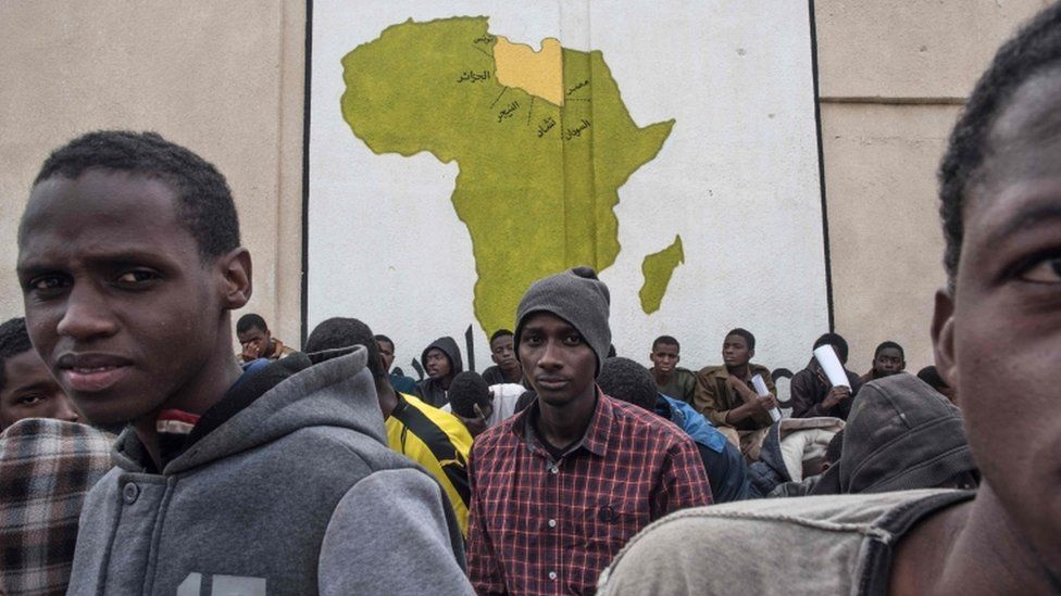 A picture taken on November 27, 2017 shows African migrants waiting outside in a courtyard at the Tariq Al-Matar detention centre on the outskirts of the Libyan capital Tripoli.