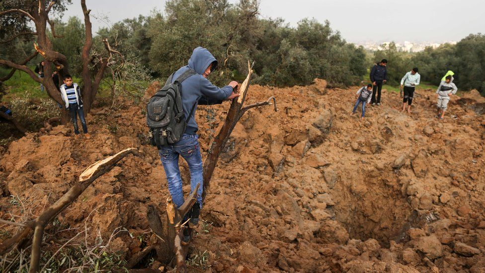 Palestinians at the site of an Israeli air strike in Gaza City on Sunday 18 February 2018