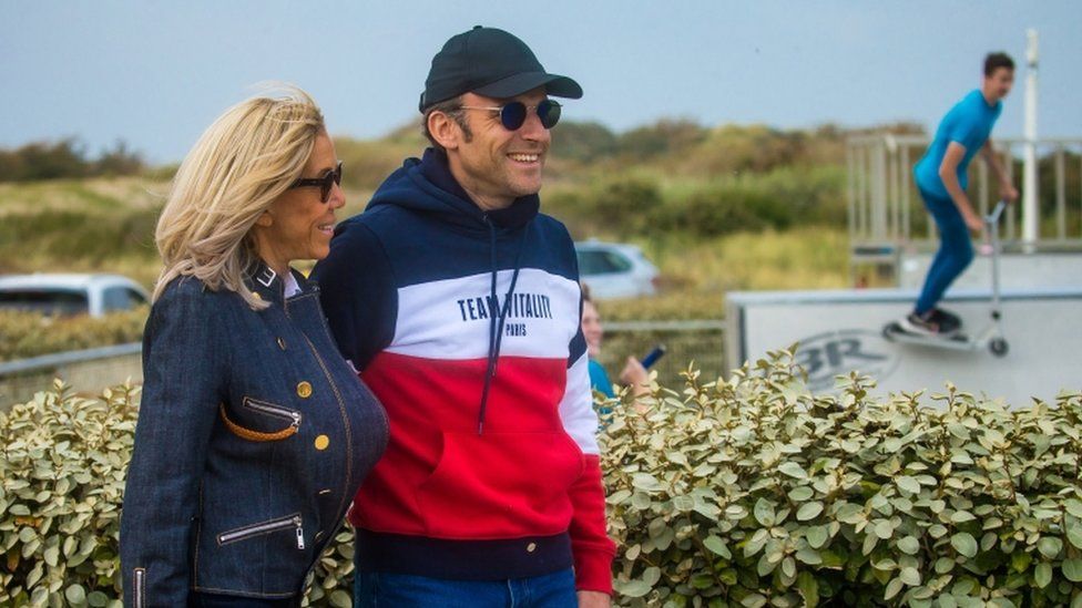 French President and candidate for re-election Emmanuel Macron (R) and his wife Brigitte Macron (L) walk on the beach of Le Touquet, France, 23 April 2022