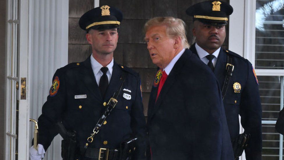 Donald Trump (C) arrives for the wake of Officer Jonathan Diller in Long Island