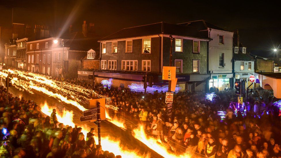 Those parading hold burning torches as they file through the streets