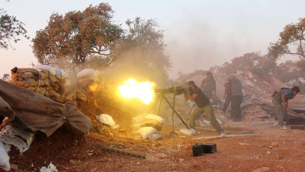 A rebel fighter fires heavy artillery during clashes with government forces in Idlib province