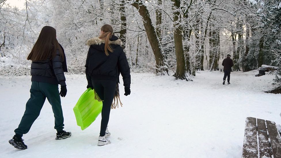 People with sledges make their way to Camp Hill in Woolton, Liverpool, on 16 January 2024
