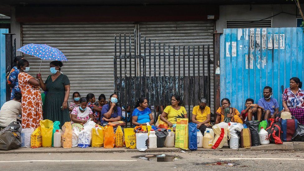 People wait to buy kerosene at a gas station amid a fuel shortage in Colombo, Sri Lanka, 17 June 2022.