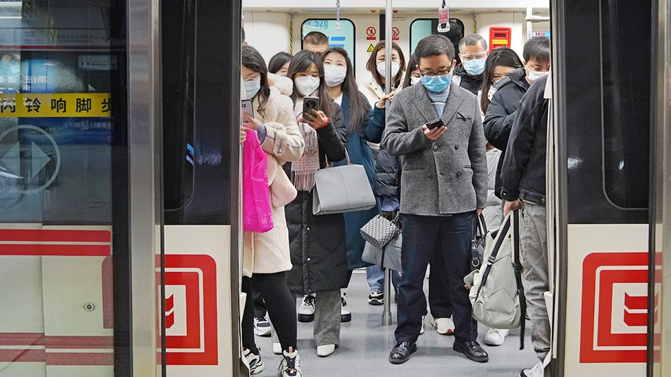 Citizens wearing masks take a subway train on December 5, 2022 in Zhengzhou, Henan Province of China