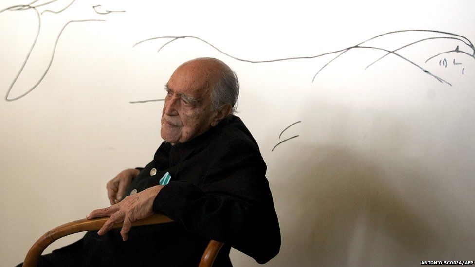Brazilian architect Oscar Niemeyer poses at his studio in front of a drawing on 14 December 2007