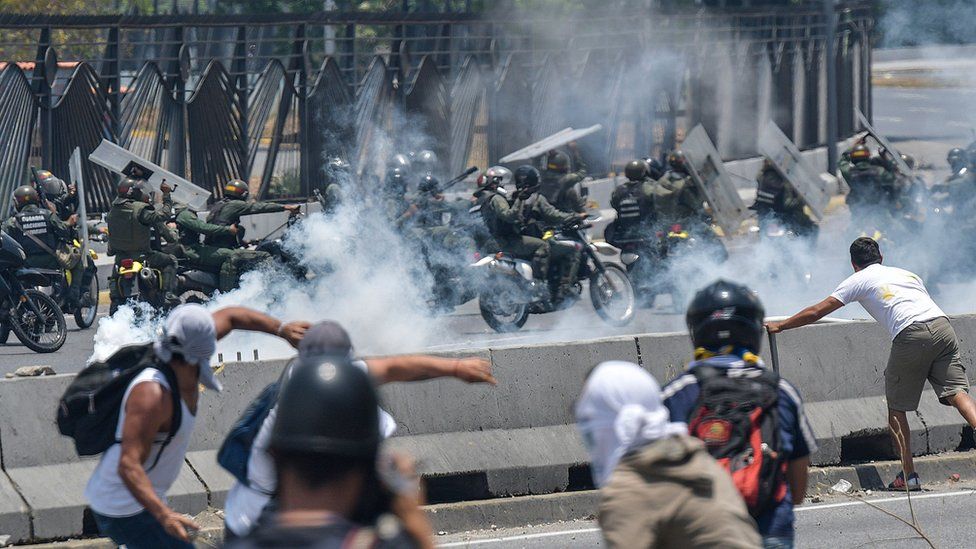 Anti-government protesters clash with security forces in the surroundings of La Carlota military base in Caracas