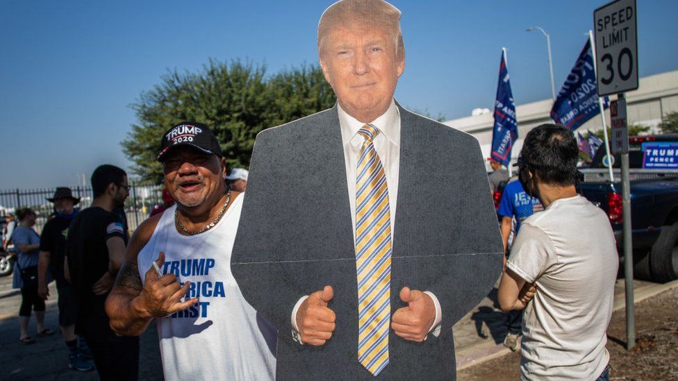 San Tee holds a President Donald Trump mannequin before a Pro-Trump car caravan in Long Beach, California on October 3, 2020