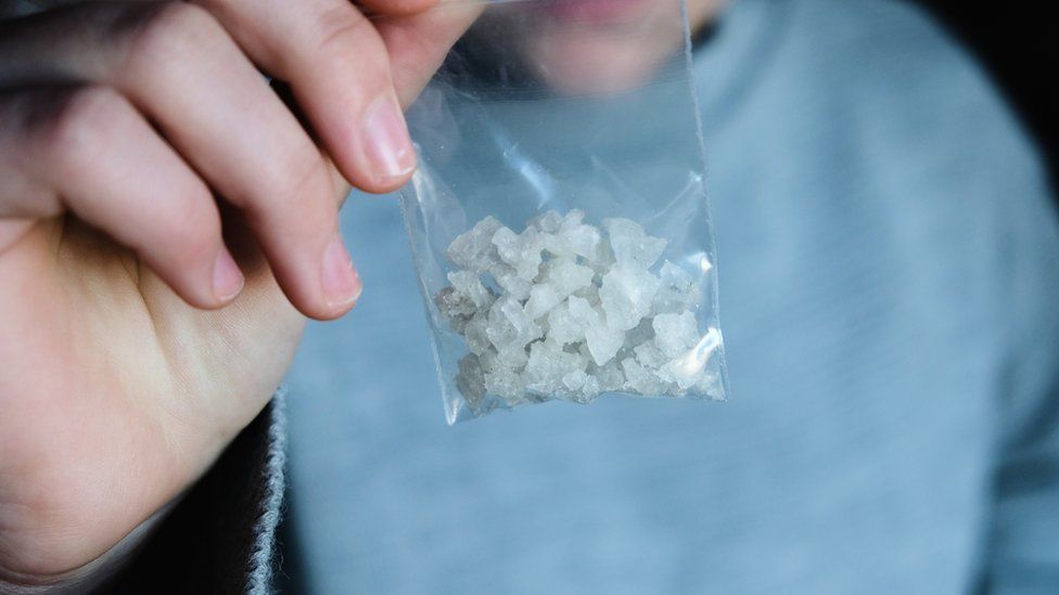 Man holds packet of suspected crack cocaine