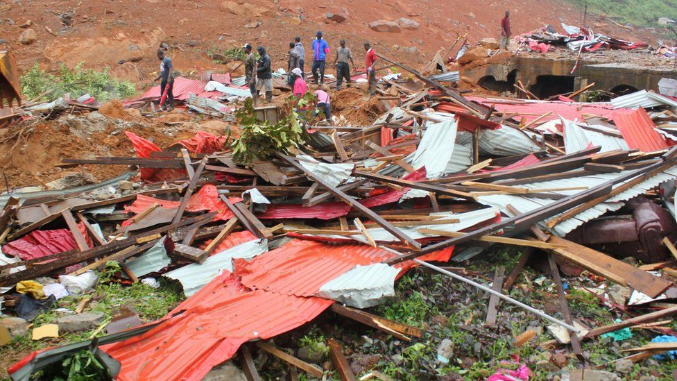 People inspect the damage after a mudslide in the mountain town of Regent, Sierra Leone August 14, 2017