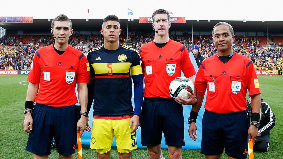 Simon with his team - referee Matthew Conger and assistant Tevita Makasini. The players is Juan Sebastian Quintero Fletcher of Colombia.