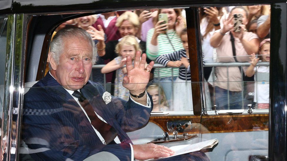 King Charles waves at crowds from a car after being proclaimed by the Accession Council