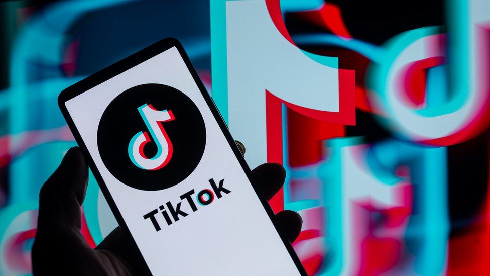 TikTok displayed on a smartphone with TikTok Icon seen in the background.