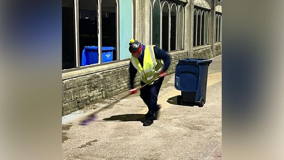 A council worker cleaning up the glass