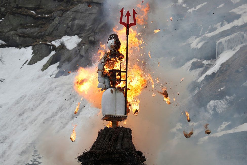 A figure of a snowman burns on the Devil's Bridge over the Schoellenen Gorge near Andermatt in Switzerland