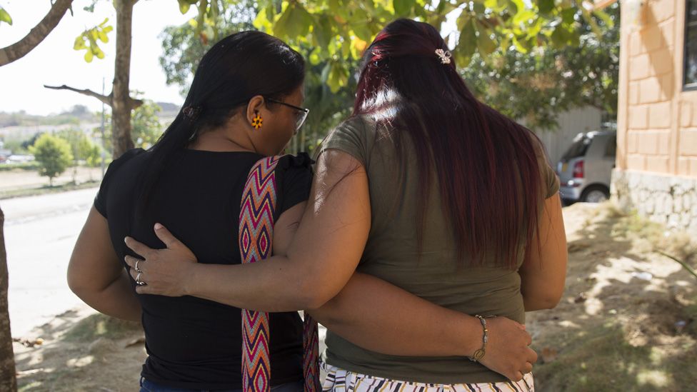 Community leaders Eidavis Montes and Lubis Cardenes embrace as they walk through the streets of their city on January 20, 2020.