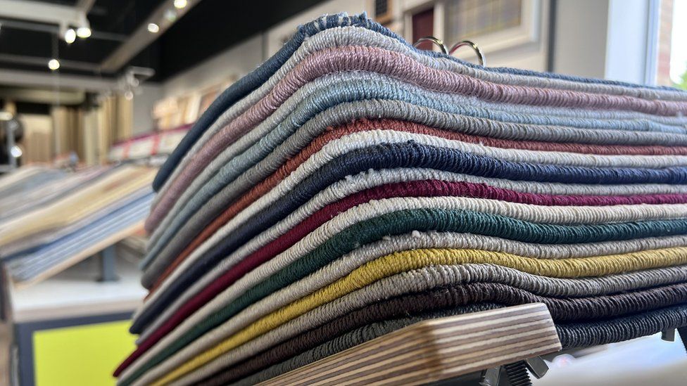 A stack of carpets in different colours