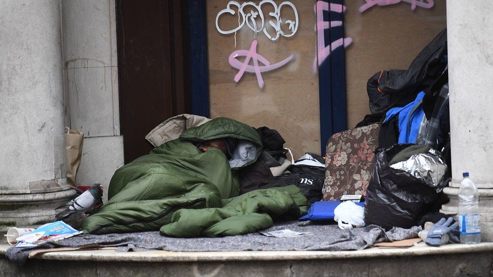 A homeless man sleeping in a doorway