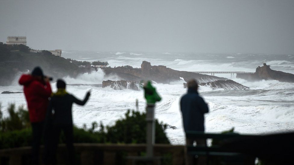 People look at the ocean;s waves hitting the coast in Biarritz, south-western France, on 03 November, 2019.