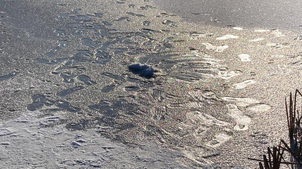 Footsteps can be seen on the ice on Beaufort Pond