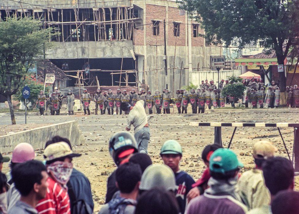 A protester throwing a stone at police amid a confrontation in Solo on 8 May 1998