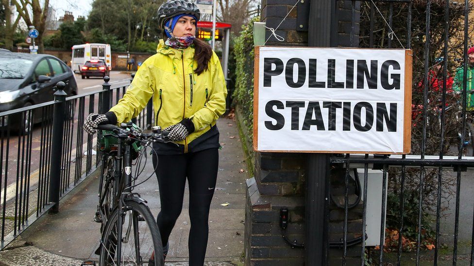 Велосипедист прибывает на избирательный участок в Харинги на севере Лондона, чтобы проголосовать на всеобщих выборах в Великобритании