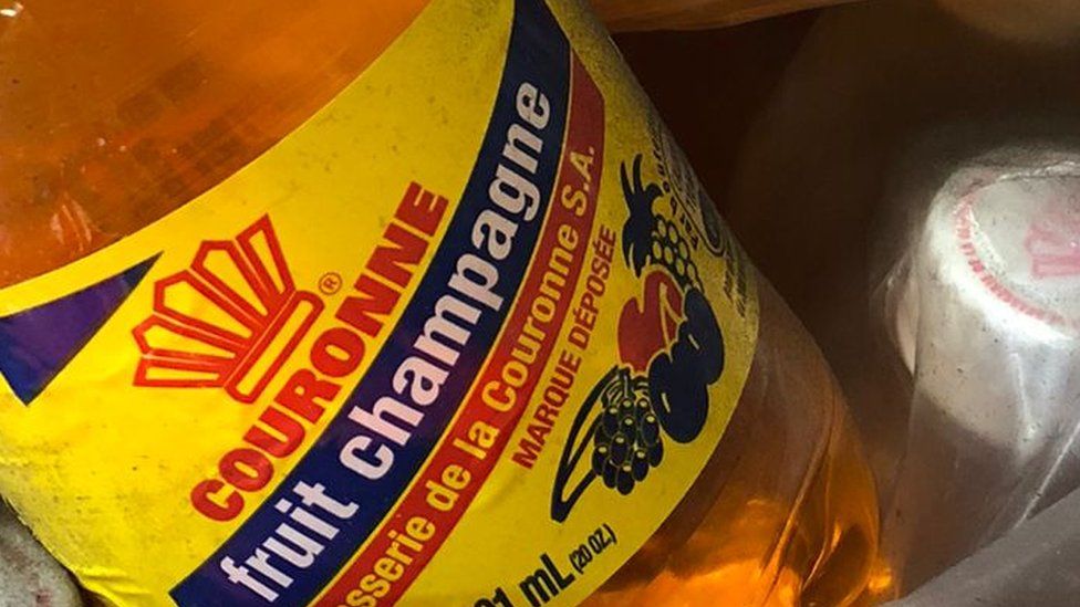 A bottle of orange drink with a label 'Fruit champagne'