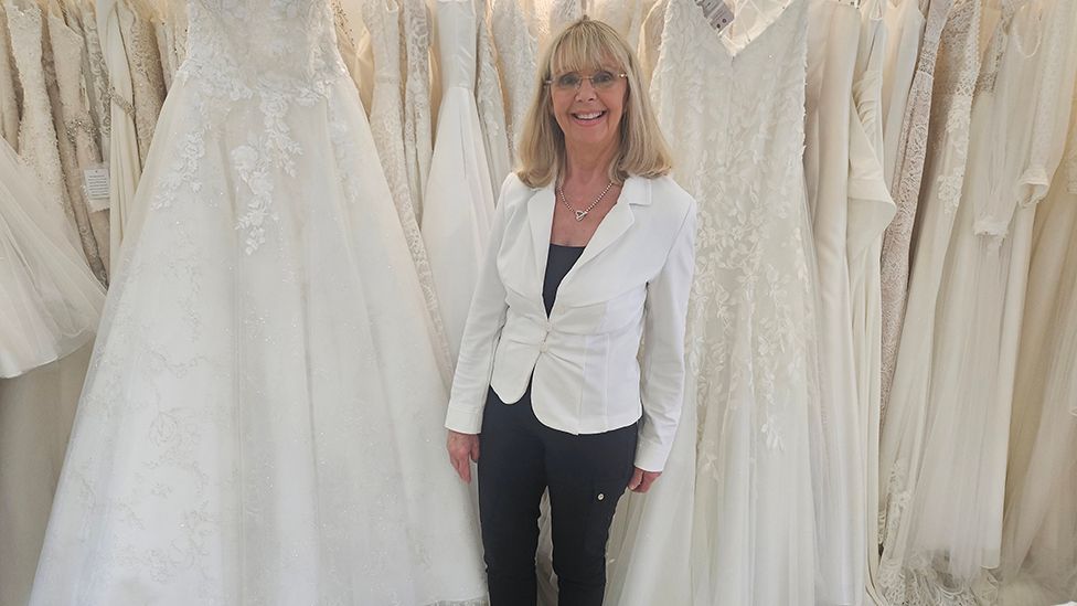 Suzie Bilton in front of wedding dresses