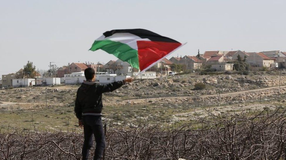 A Palestinian holds the Palestinian flag during a protest in the West Bank village of Twani, near Hebron, 10 February 2017.