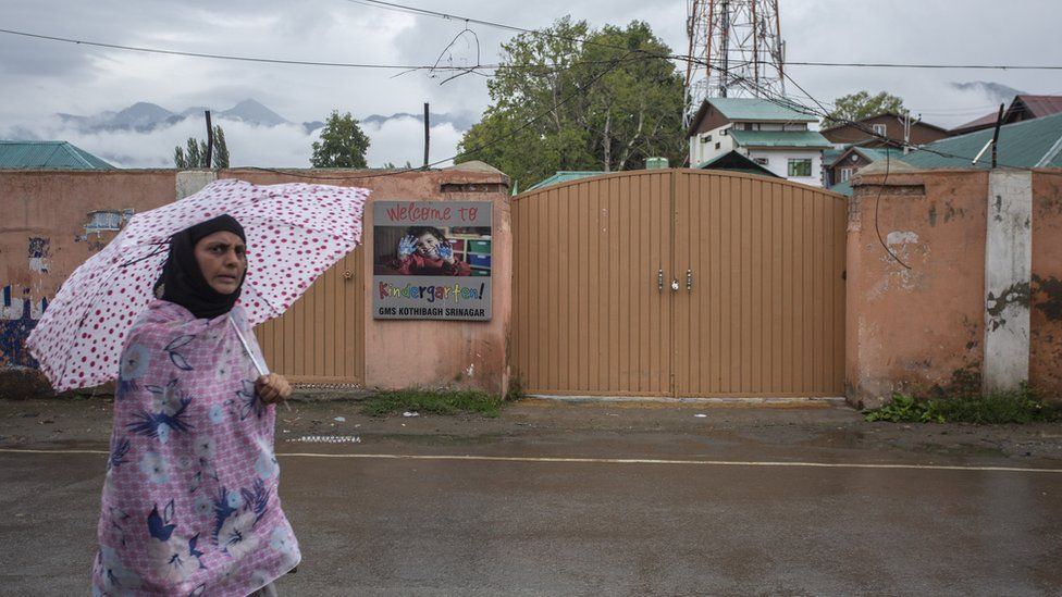 A woman walks in front of a shut primary school