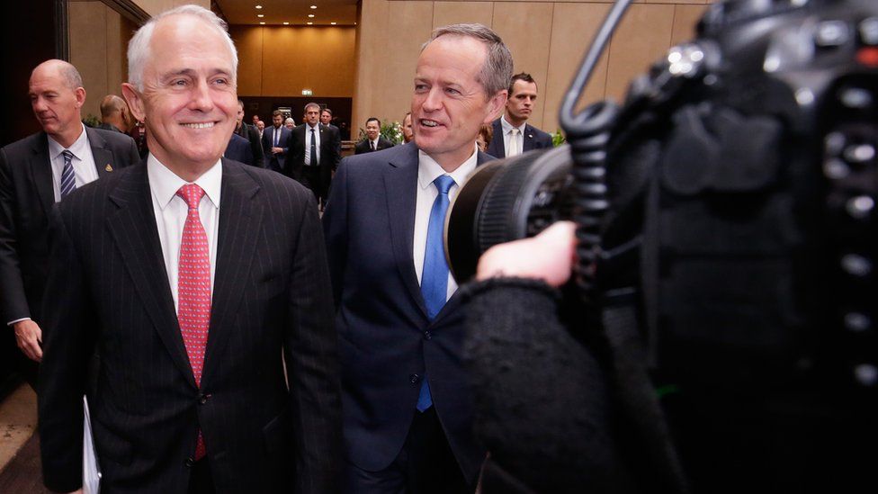 Prime Minister Malcolm Turnbull and Opposition Leader Bill Shorten walk through the media scrum on the campaign trail