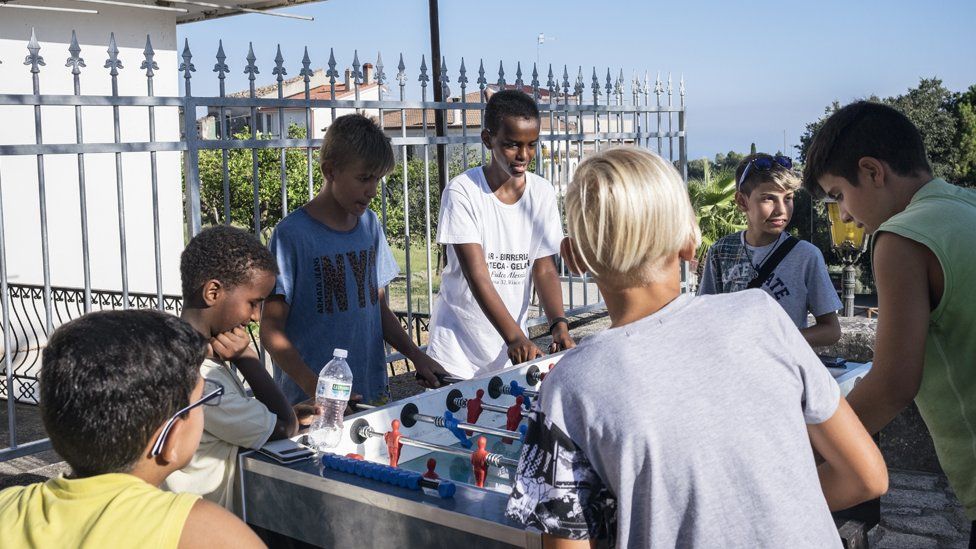 Children play table football in Riace
