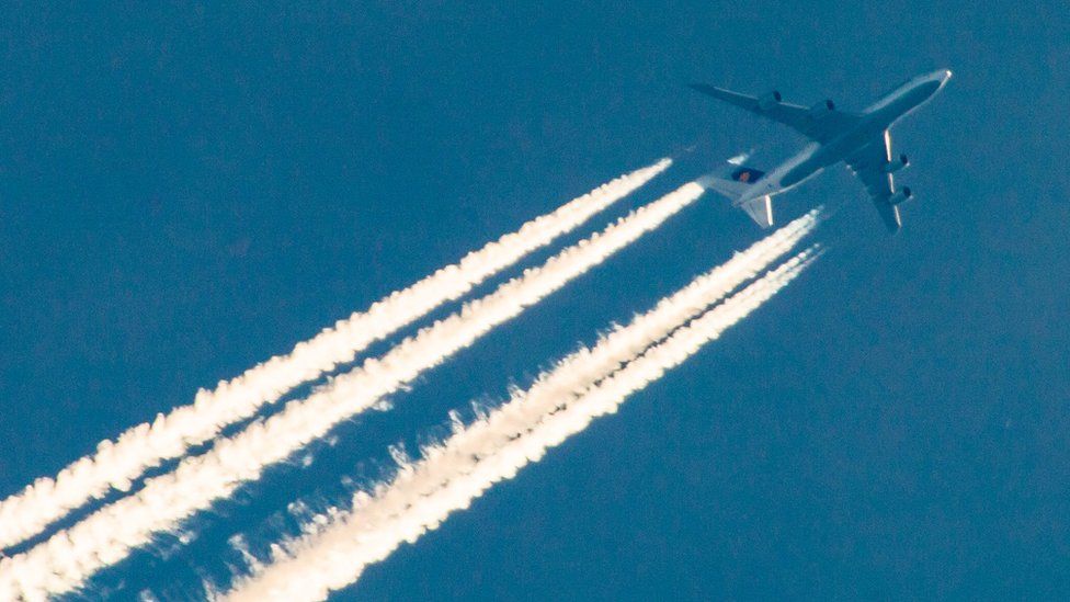 A passenger aircraft and its engine exhaust contrails