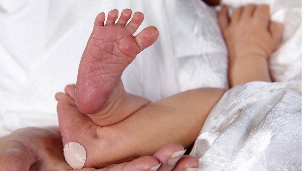 Newborn baby with a plaster on its heel