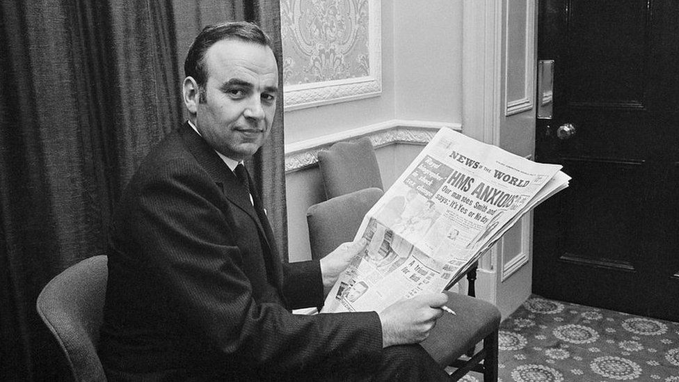 Rupert Murdoch holding a copy of his News Of The World newspaper in London on 25 October 1968