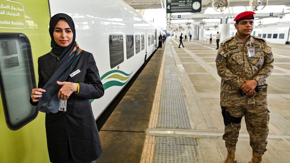 An employee stands outside a train at the airport station in Jeddah, Saudi Arabia
